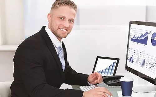 Multiple-Reports Man on a computer that has various graphs on the screen